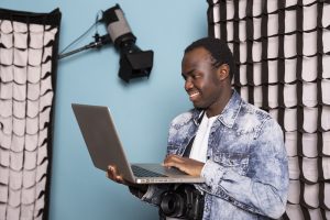 photographer holding laptop in studio